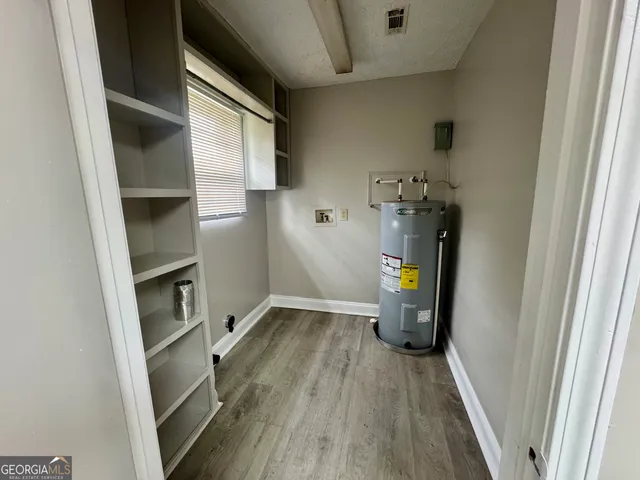 a view of water heater room with wooden floor