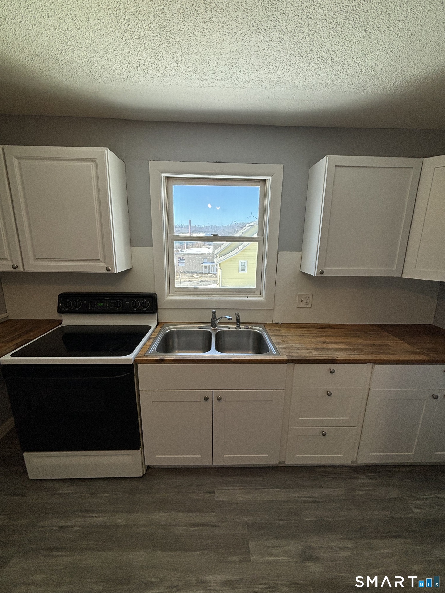 11 Roberts Street, Unit 2 Bristol, CT 06010 - Photo 3 of 11 a kitchen with stainless steel appliances a sink a stove a microwave a counter top and cabinets