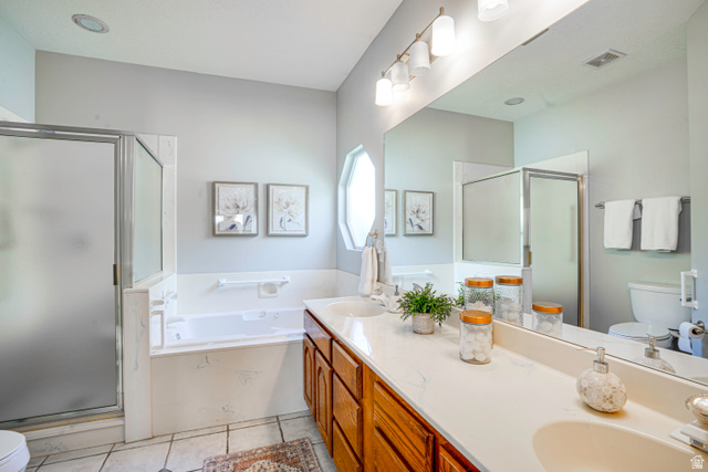 1433 Forge Way Draper, UT 84020 - Photo 16 of 29 Double vanity with integrated sinks and wood cabinetry, large soaking tub, separate shower with frosted glass enclosure, and a prominent wall-mounted mirror