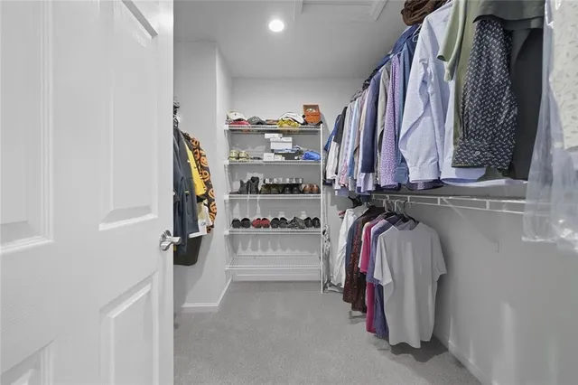 a view of walk in closet with clothes and shoes