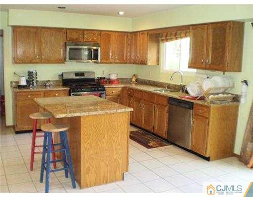 26 Churchill Road Edison, NJ 08820 - Photo 4 of 13 a kitchen with stainless steel appliances a stove a sink a microwave a sink and cabinets
