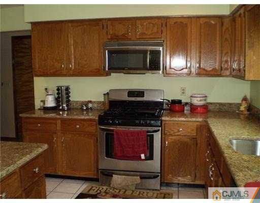 26 Churchill Road Edison, NJ 08820 - Photo 5 of 13 a kitchen with stainless steel appliances granite countertop a stove a microwave a sink and cabinets