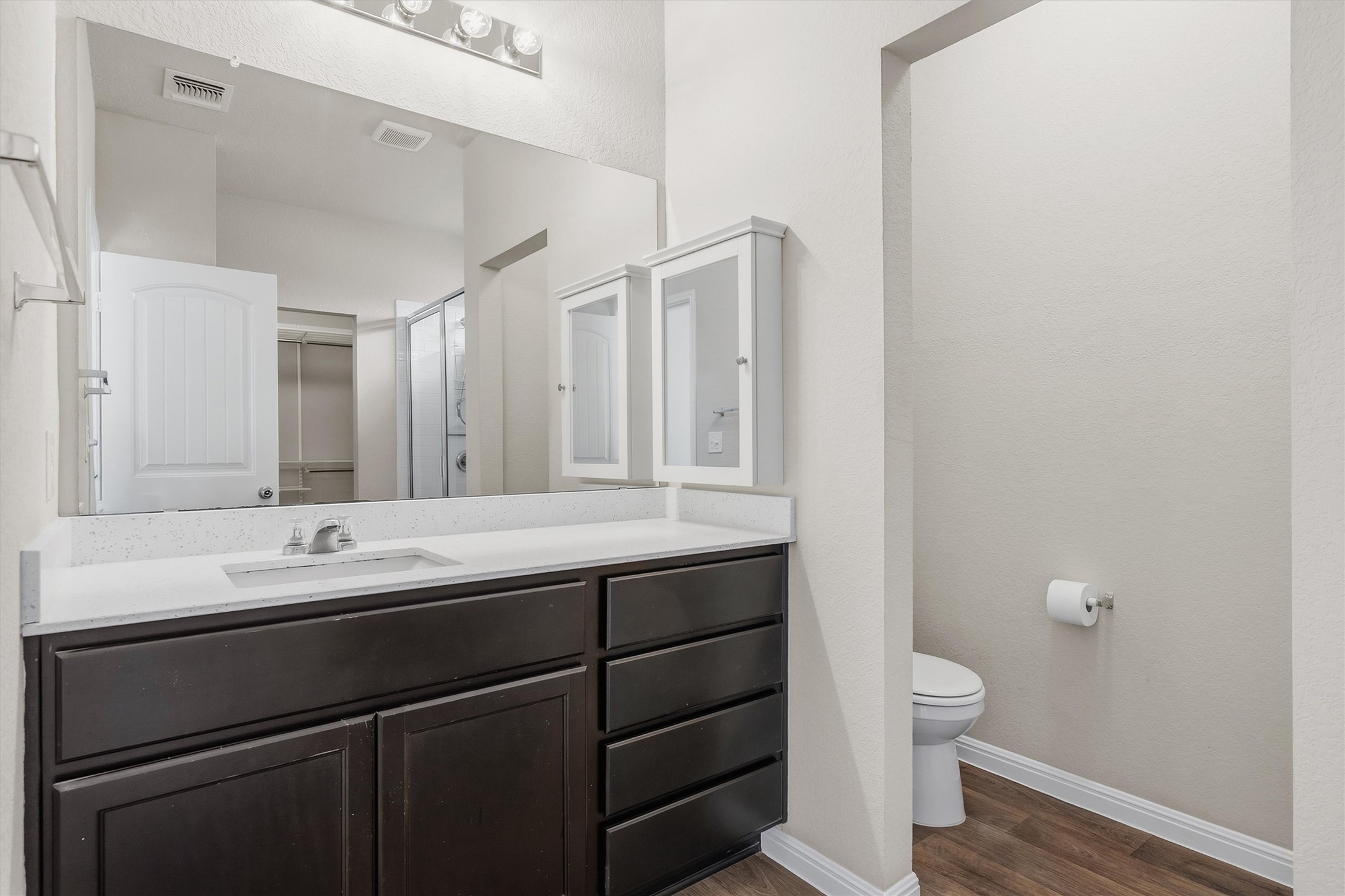 10817 Gonzales Ranger Pass Austin, TX 78754 - Photo 14 of 37 The primary bath features a rich wood vanity and walk in shower.