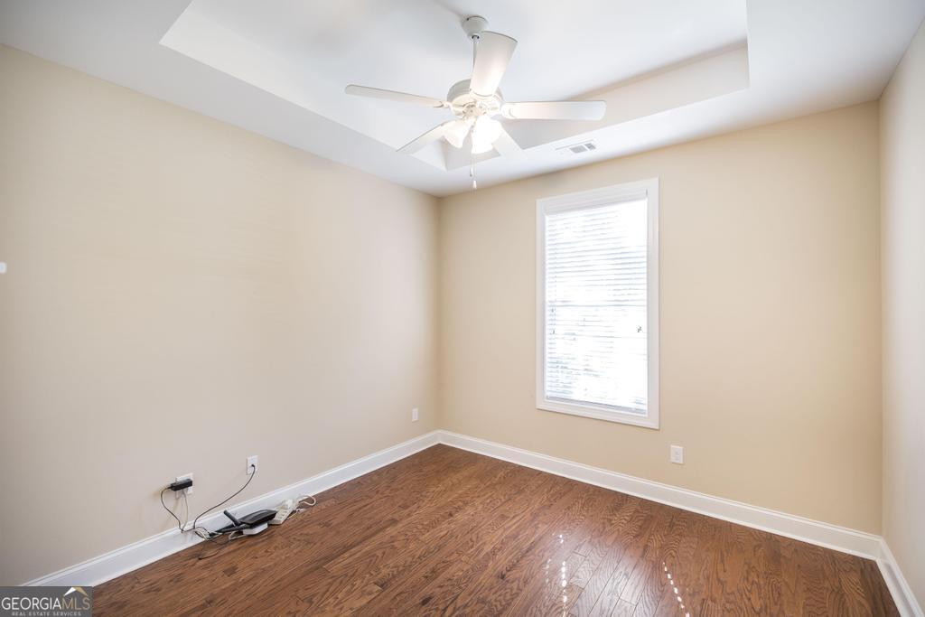 206 Londe Lane Perry, GA 31069 - Photo 27 of 37 an empty room with wooden floor chandelier fan and windows