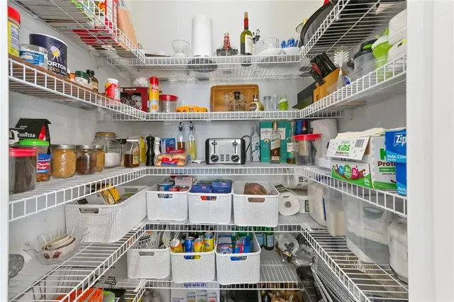 a utility room with stainless steel appliances and white cabinets