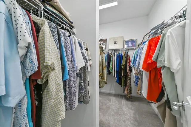a view of walk in closet with clothes