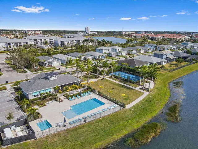 an aerial view of a pool an outdoor space and seating area