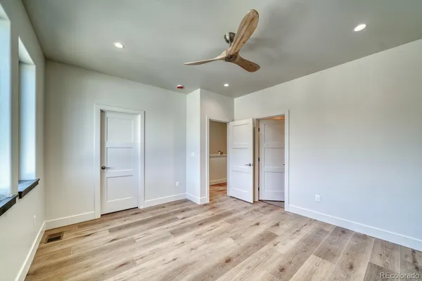 a view of a livingroom with a ceiling fan and wooden floor