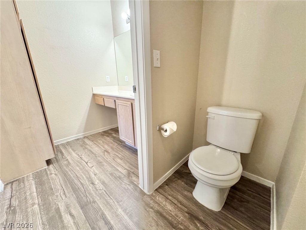 8070 West Russell Road, Unit 2121 Las Vegas, NV 89113 - Photo 18 of 22 Functional bathroom featuring a vanity area with a mirror and sleek wood-look flooring.