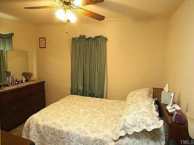 536 Marble Street Raleigh, NC 27603 - Photo 6 of 8 a bedroom with a bed and a chandelier
