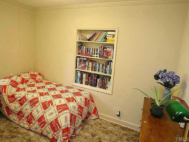 536 Marble Street Raleigh, NC 27603 - Photo 7 of 8 a bedroom with a bed and a book shelf