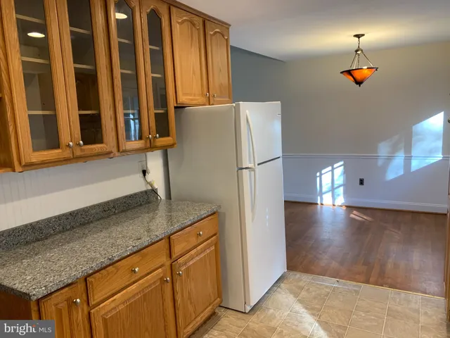 a kitchen with stainless steel appliances granite countertop a refrigerator a sink and a counter space