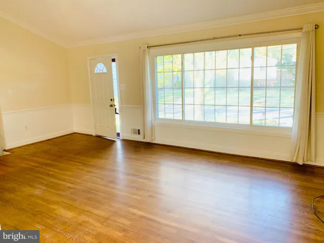 wooden floor in an empty room with a window