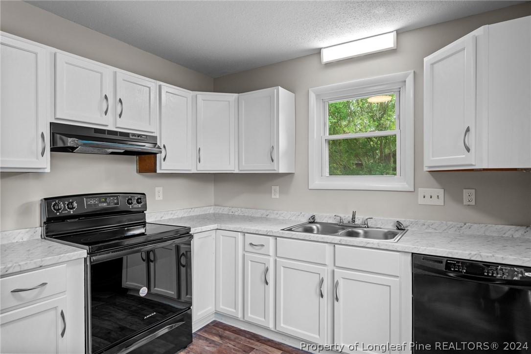 112 Maranatha Circle Spring Lake, NC 28390 - Photo 18 of 33 a kitchen with white cabinets and a stove top oven