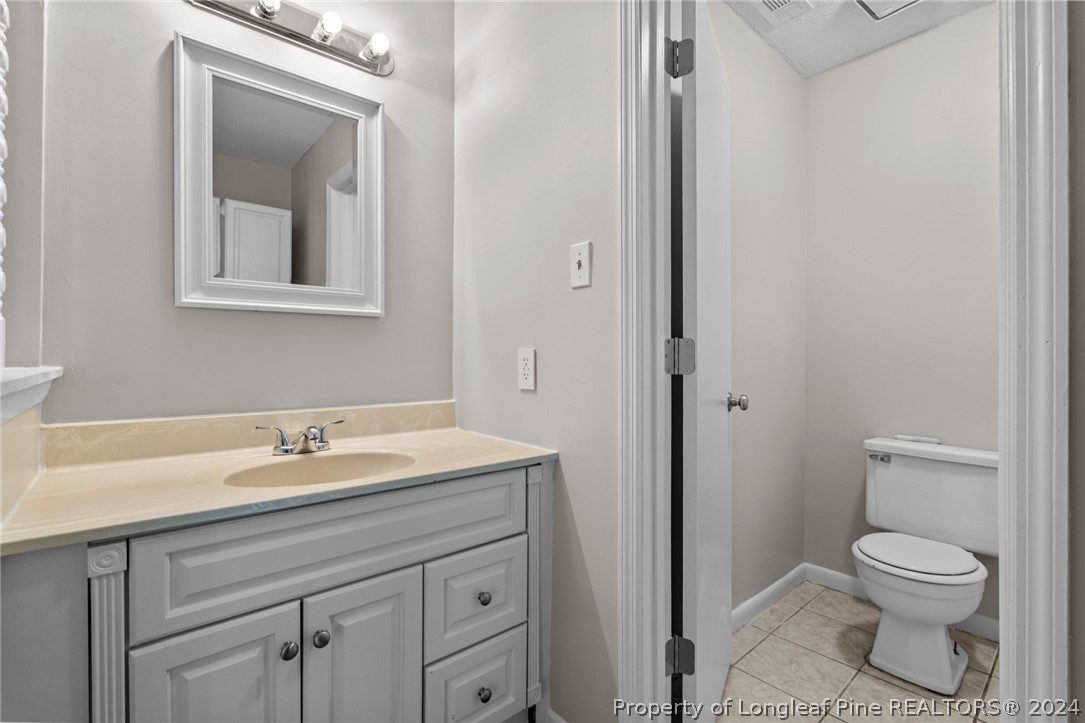 112 Maranatha Circle Spring Lake, NC 28390 - Photo 26 of 33 a bathroom with a toilet sink and mirror