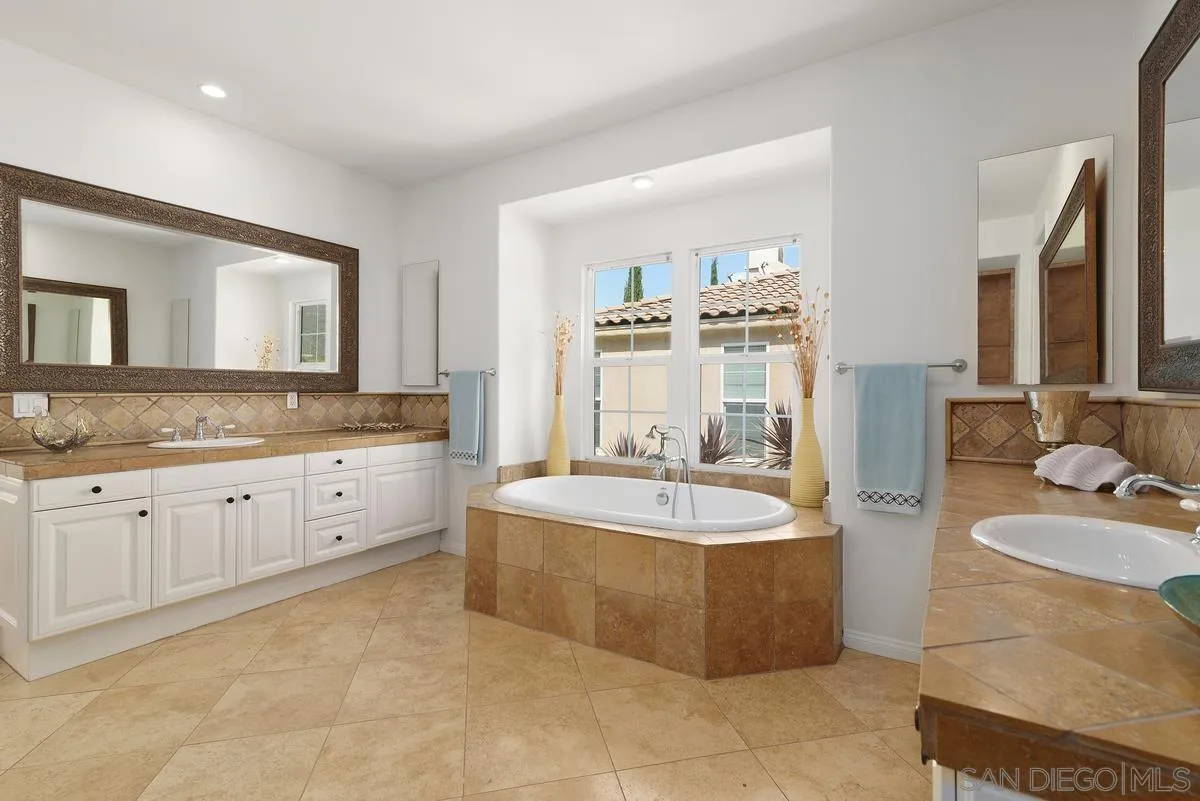 7542 Circulo Sequoia Carlsbad, CA 92009 - Photo 15 of 24 a spacious bathroom with a granite countertop tub sink and mirror