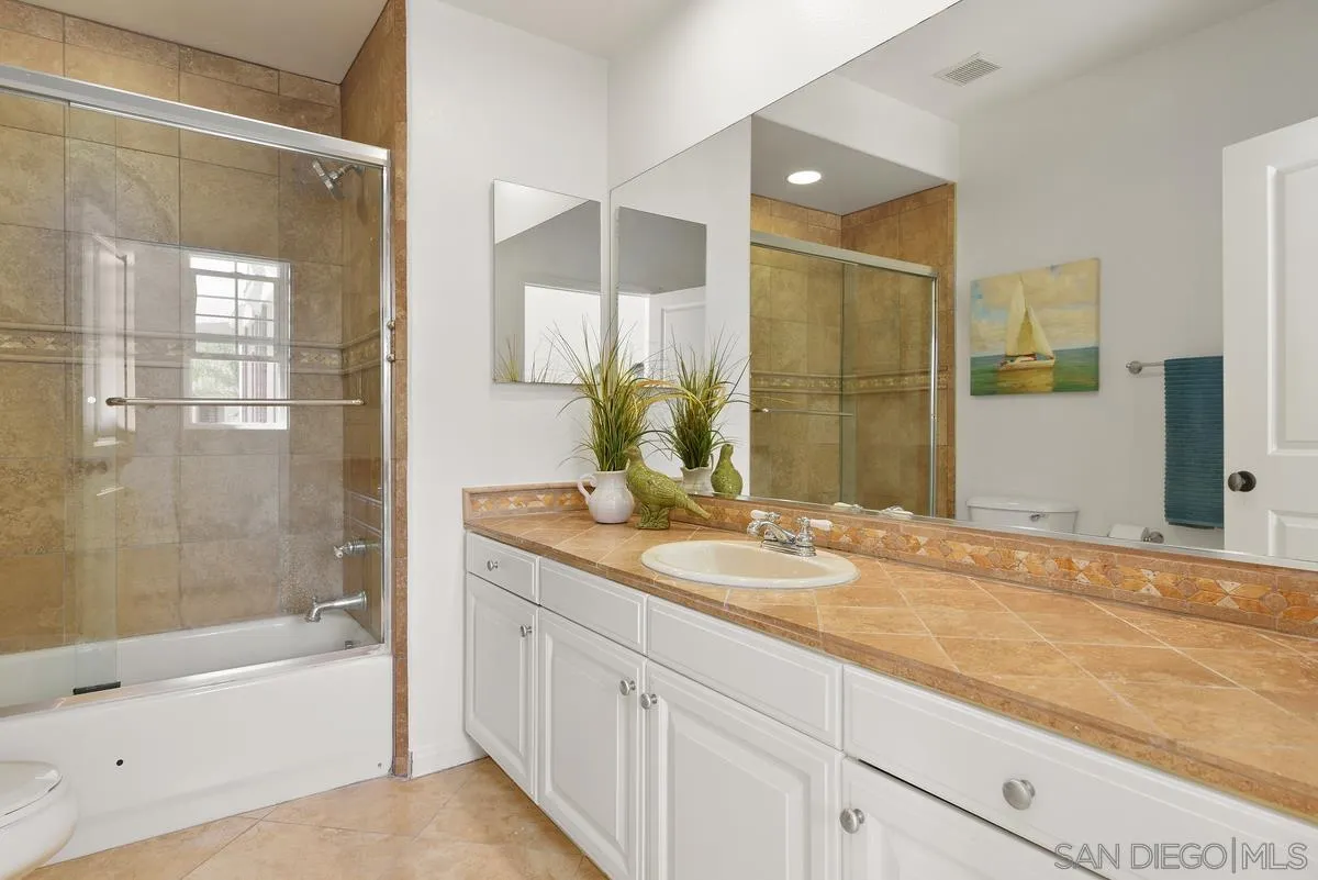 7542 Circulo Sequoia Carlsbad, CA 92009 - Photo 17 of 24 a bathroom with a granite countertop sink mirror bathtub and shower
