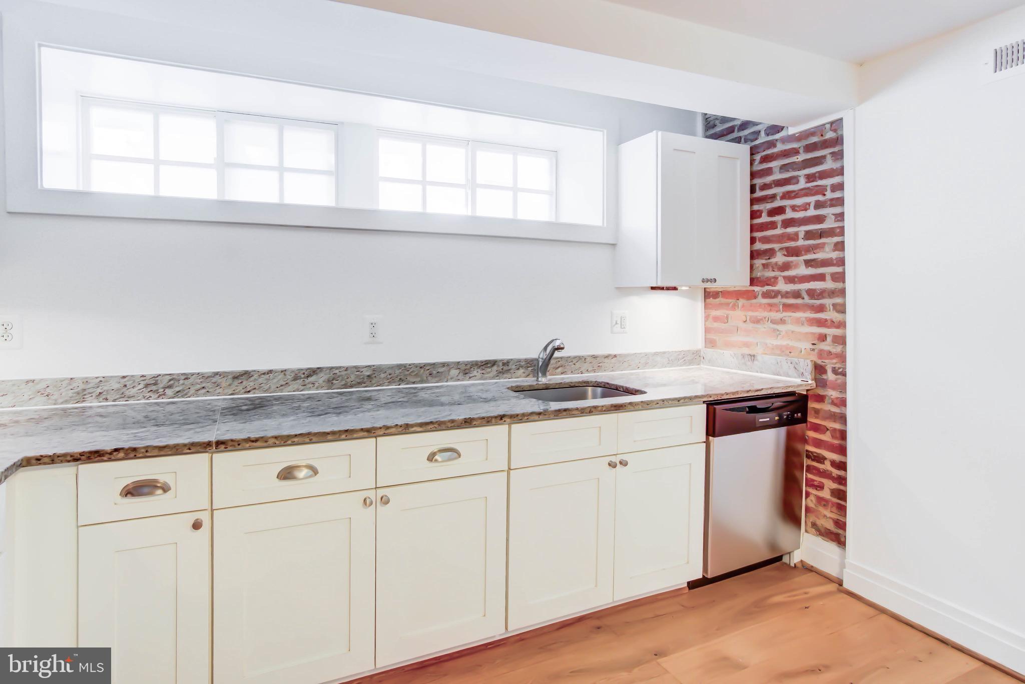3625 16th Street Northwest, Unit B1 Washington, DC 20010 - Photo 4 of 15 a kitchen with granite countertop white cabinets and a sink
