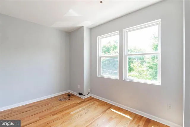 a view of a bedroom with wooden floor and a window