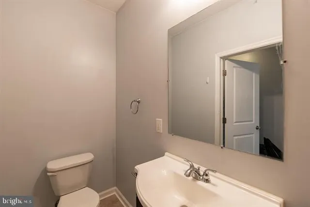a bathroom with a sink mirror and toilet