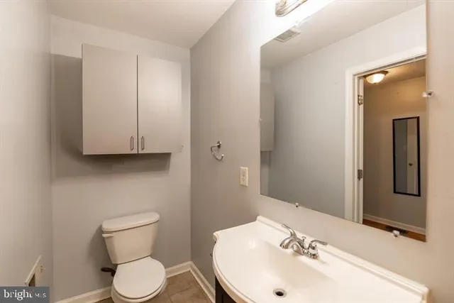 a bathroom with a sink a toilet and mirror