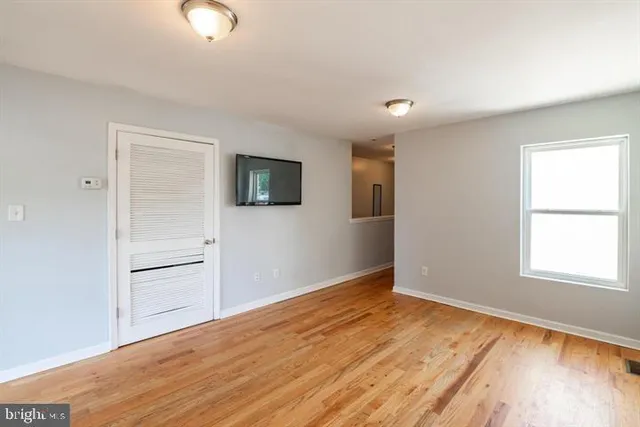 wooden floor in an empty room with a window