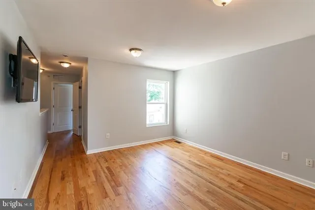 wooden floor in an empty room with a window