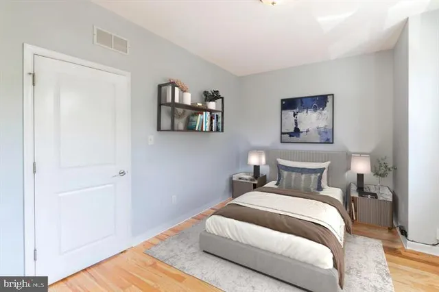 a bedroom with bed and painting on the wall