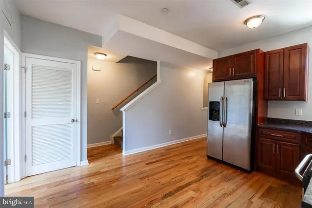 a kitchen with granite countertop stainless steel appliances a refrigerator and cabinets