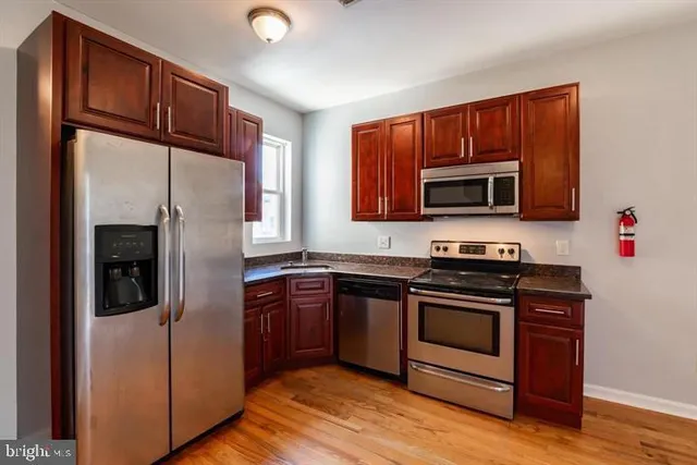 a kitchen with stainless steel appliances granite countertop a refrigerator stove and microwave