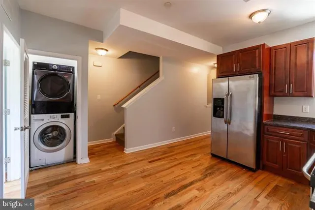 a kitchen with wooden floor and refrigerator