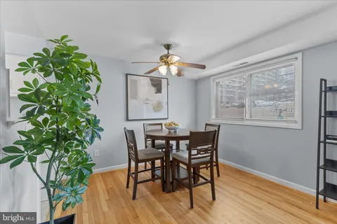 a dining room with furniture a chandelier and wooden floor