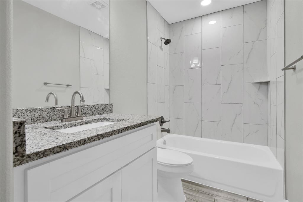 622 East Heron Street Denison, TX 75021 - Photo 13 of 20 Bathroom with bathing tub / shower combination, vanity, and light wood-style floors