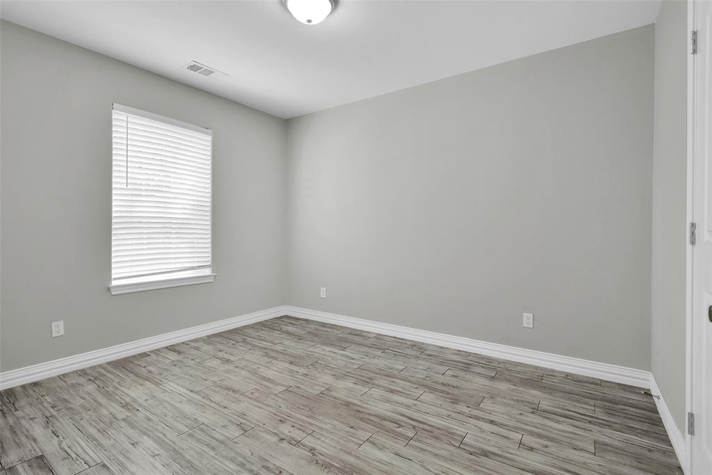 622 East Heron Street Denison, TX 75021 - Photo 14 of 20 Empty room with baseboards and wood finished floors