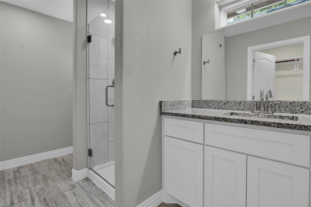 622 East Heron Street Denison, TX 75021 - Photo 17 of 20 Full bath with a stall shower, vanity, and light wood-style floors