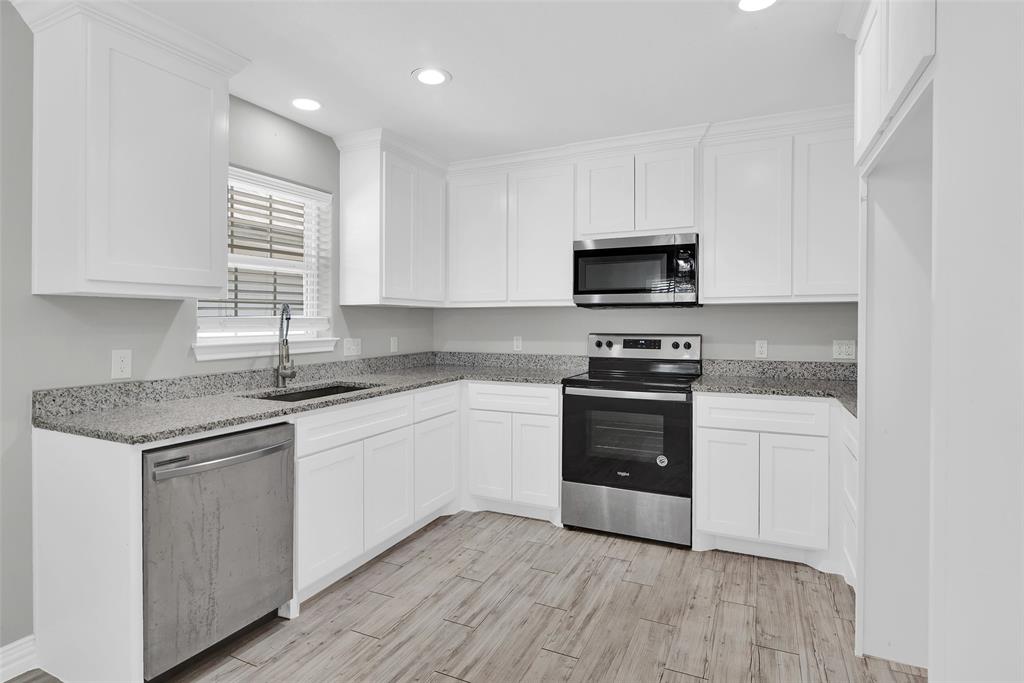 622 East Heron Street Denison, TX 75021 - Photo 9 of 20 Kitchen with light stone counters, stainless steel appliances, white cabinetry, wood finish floors, and recessed lighting