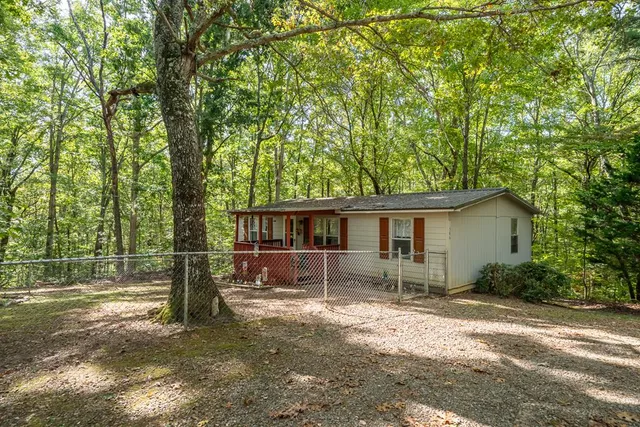 a view of a house with backyard and a tree
