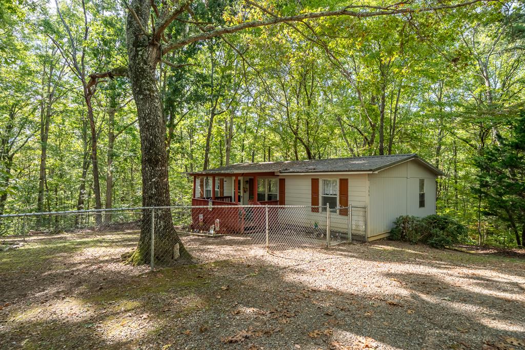 a view of a house with backyard and a tree
