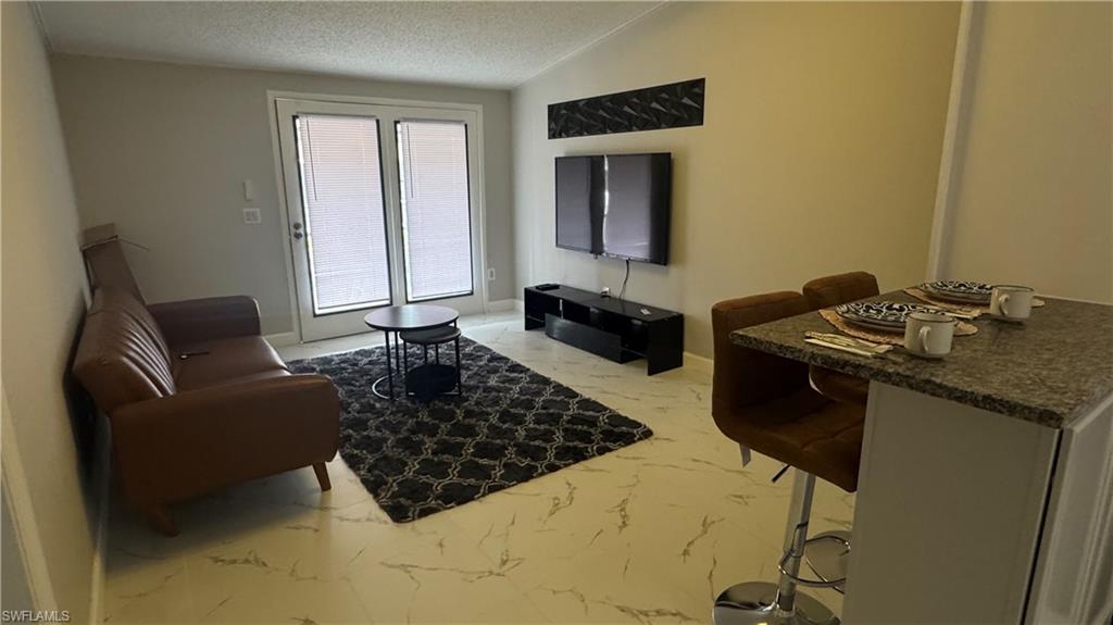 5222 Treetops Drive Naples, FL 34113 - Photo 4 of 9 a living room with furniture and a rug