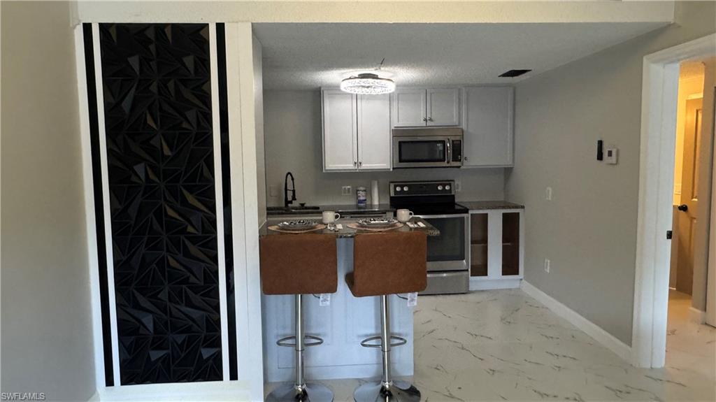 5222 Treetops Drive Naples, FL 34113 - Photo 6 of 9 a kitchen with a refrigerator and a stove top oven