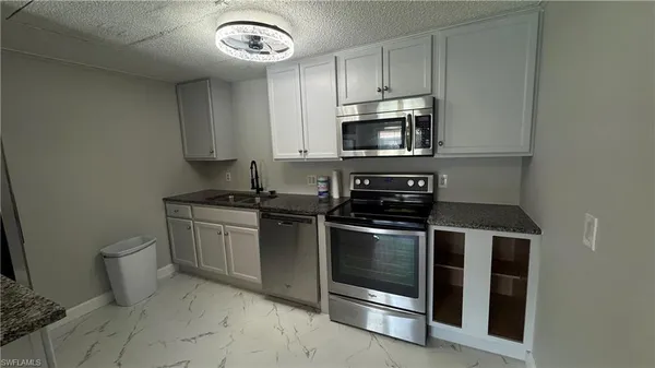 a kitchen with stainless steel appliances granite countertop a stove microwave and sink