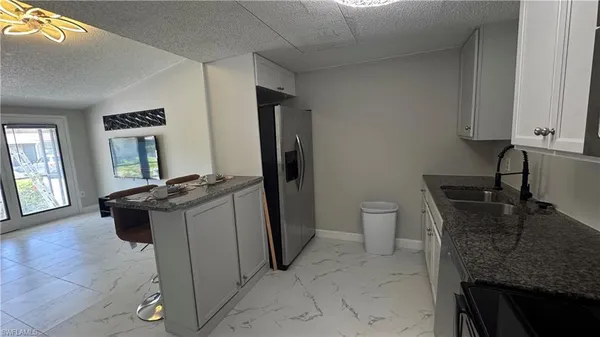 a bathroom with a granite countertop sink a toilet and mirror