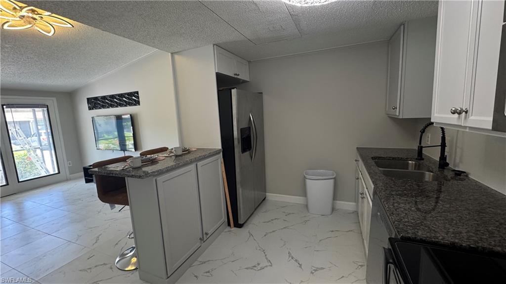 5222 Treetops Drive Naples, FL 34113 - Photo 8 of 9 a bathroom with a granite countertop sink a toilet and mirror