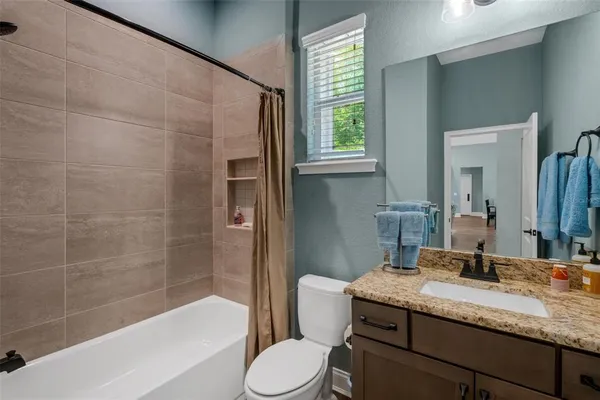 a bathroom with a granite countertop sink toilet and shower