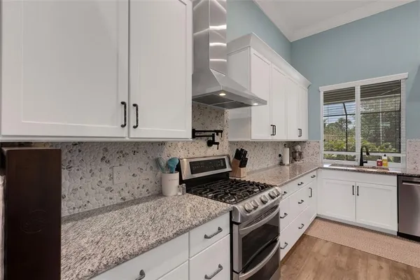 a kitchen with granite countertop a sink stove and cabinets