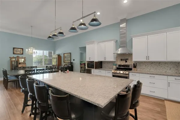 a kitchen with stainless steel appliances granite countertop a kitchen island a stove a table and chairs in it