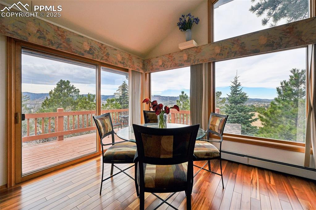 17580 Chipped Arrow Way Monument, CO 80132 - Photo 18 of 50 a dining room with furniture wooden floor and a floor to ceiling window
