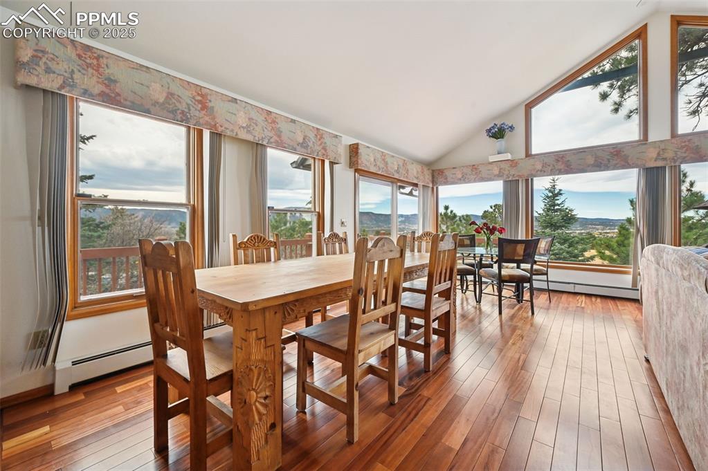 17580 Chipped Arrow Way Monument, CO 80132 - Photo 19 of 50 a dining room with furniture floor to ceiling windows and wooden floor