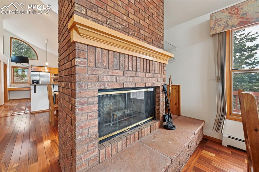 17580 Chipped Arrow Way Monument, CO 80132 - Photo 20 of 50 a living room with a fireplace furniture and a wooden floor