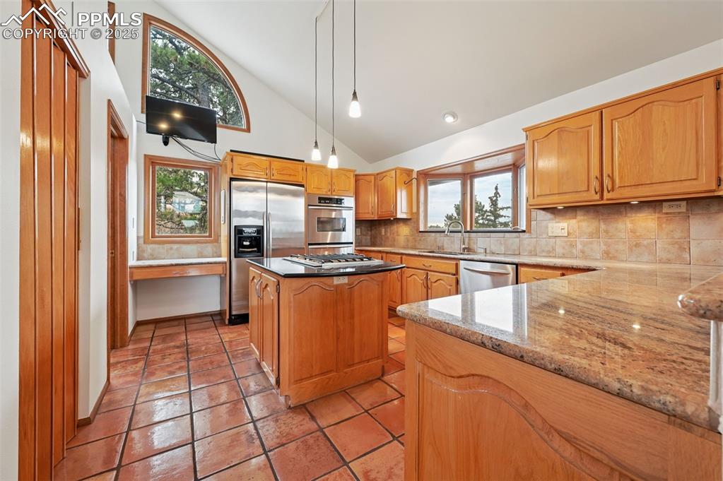 17580 Chipped Arrow Way Monument, CO 80132 - Photo 22 of 50 a kitchen with stainless steel appliances granite countertop a stove a sink and a microwave